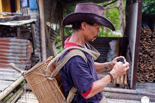 local guide - annah rais longhouse (borneo), annah rais, backpack, borneo, cellphone, leather hat, longhouse, malaysia, man, village