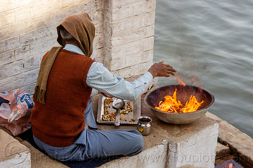 man burning hindu offerings on the ghats of varanasi (india), burning, fire, ganga, ganges river, ghats, hindu, hinduism, india, man, offerings, sitting, varanasi