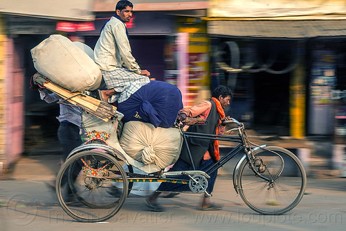 man sitting on top of large sacks on cycle rickshaw (india), bags, cargo, cycle rickshaw, freight, heavy, load, men, moving, sacks, sitting, transport, transportation, transporting, varanasi, walking