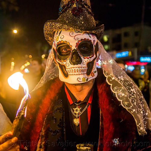 man with sugar skull mask and white lace, burning, day of the dead, dia de los muertos, fire, glittery hat, halloween, lace, man, necklace, night, red, skull mask, veil