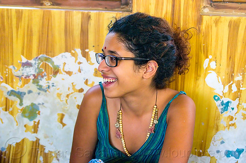 maryam and peeling paint wall, bindi, bracelets, djembe drum, drummer, eyeglasses, eyewear, maryam, musical instrument, necklaces, peeling paint, percussion, prescription glasses, rishikesh, sitting, spectacles, woman