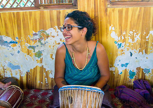 maryam with djembe drum, bindi, bracelets, djembe drum, drummer, eyeglasses, eyewear, maryam, musical instrument, necklaces, peeling paint, percussion, prescription glasses, rishikesh, sitting, spectacles, woman