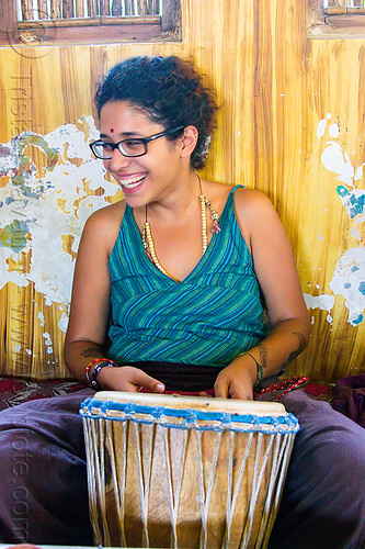 maryam with djembe drum, bindi, bracelets, djembe drum, drummer, eyeglasses, eyewear, maryam, musical instrument, necklaces, peeling paint, percussion, prescription glasses, rishikesh, sitting, spectacles, woman