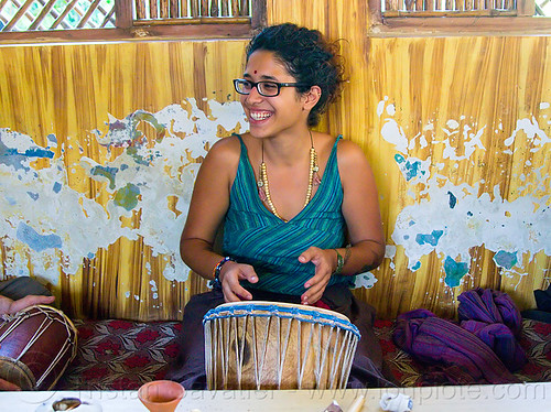 maryam with djembe drum, bindi, bracelets, djembe drum, drummer, eyeglasses, eyewear, maryam, musical instrument, necklaces, peeling paint, percussion, prescription glasses, rishikesh, sitting, spectacles, woman