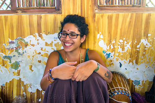 maryam with djembe drum, bindi, bracelets, djembe drum, drummer, eyeglasses, eyewear, maryam, musical instrument, necklaces, peeling paint, percussion, prescription glasses, rishikesh, sitting, spectacles, woman