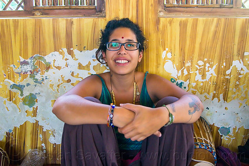 maryam with djembe drum, bindi, bracelets, djembe drum, drummer, eyeglasses, eyewear, lip piercing, maryam, musical instrument, necklaces, peeling paint, percussion, prescription glasses, rishikesh, sitting, spectacles, woman