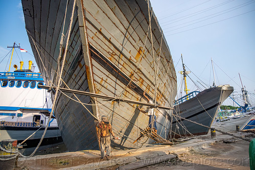 men repainting pinisi wooden boat hull, boats, bugis schooners, dock, harbor, men, painting, pinisi, ships, surabaya, suspended scaffold