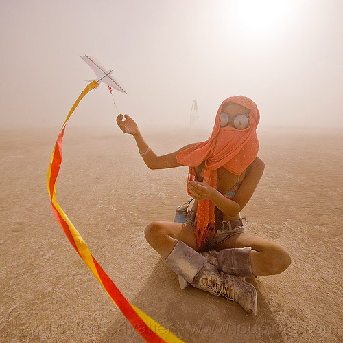 mini kite, boots, cross-legged, dust storm, flying, goggles, haboob, minah, mini kite, orange scarf, playa dust, red, sitting, streamers, string, whiteout, wind, woman, yellow