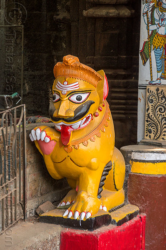 mustachioed stone tiger guarding hindu temple (india), bhubaneswar, hindu temple, hinduism, lingaraj temple, lingaraja temple, mustache, painted, sculpture, statue, sticking out tongue, sticking tongue out, stone tiger, tilak, tilaka, yellow