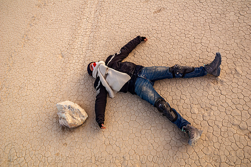 my friend pretending she was hit by a moving sailing stone on the racetrack - death valley, cracked mud, death valley, dry lake, dry mud, laying, racetrack playa, sailing stones, sliding rocks, spread eagle, woman