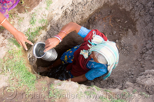 old woman getting drinking water from water hole - mandu (india), indian woman, mandav, mandu, water hole