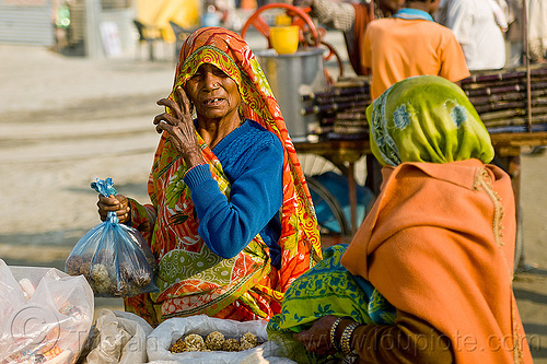 old woman selling puffed rice balls (india), hindu pilgrimage, hinduism, india, maha kumbh mela, offerings, old woman, plastic bags, street food, street seller, street vendor, women
