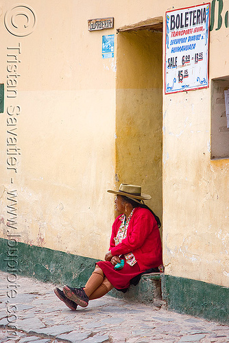 old woman waiting for the bus (argentina), argentina, boleteria, cobblestones, door, doorway, hat, house, indigenous, iruya, noroeste argentino, porch, quebrada de humahuaca, quechua, red, sitting, woman