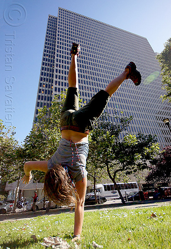 one hand cartwheeling, cartwheeling, catrwheel, city park, gymnastics, hirise building, jessika, lawn, one hand, single handed, trees, upside-down, woman