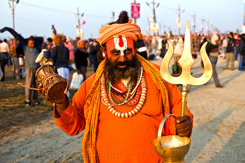 orange sadhu with golden trident and ritual drum - kumbh mela 2013 (india), baba, beard, bhagwa, damaru drum, golden pot, golden vessel, headdress, hindu man, hindu pilgrimage, hindu ritual drum, hinduism, kumbh mela, necklaces, paush purnima, pilgrim, ramanandi tilak, sadhu, saffron color, scarf, small drum, tilaka, trident, turban