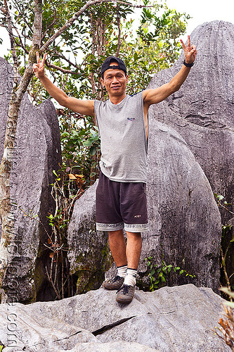 park guide ipoi lawin at the mulu pinnacles summit (borneo), borneo, geology, guide, gunung mulu national park, ipoi, limestone, malaysia, man, peace sign, pinnacles, rocks