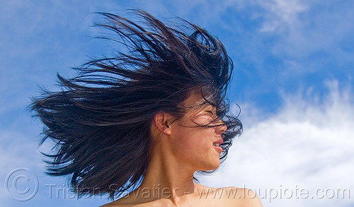 portrait of young chinese woman with hair in the wind, blowing, blue sky, chinese woman, clouds, wind, windy