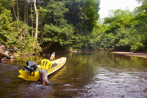 pushing a boat in the shallow waters of sungai melinau river - mulu (borneo), boatman, boatmen, borneo, gunung mulu national park, jungle, malaysia, melinau river, men, rain forest, river bed, river boat, rocks, shallow river, small boat, sungai melinau, trees