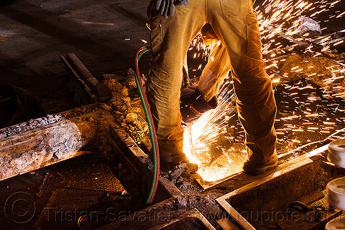 railroad worker cutting a track rail with a oxy-acetylene torch, high-visibility jacket, high-visibility vest, light rail, man, muni, night, ntk, oxy-acetylene cutting torch, oxy-fuel cutting, rail frog, railroad construction, railroad tracks, railway tracks, reflective jacket, reflective vest, safety glasses, safety gloves, safety helmet, safety vest, san francisco municipal railway, sparks, track crossing, track maintenance, track work, welder, worker