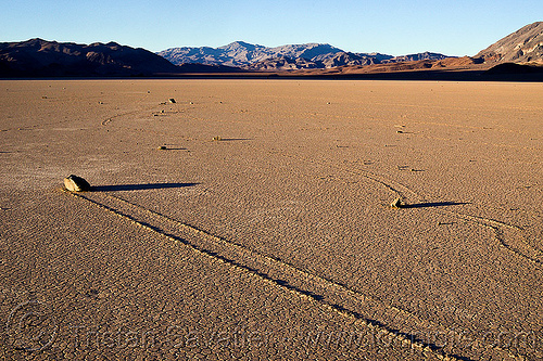 several sailing stones on the racetrack - death valley, cracked mud, death valley, dry lake, dry mud, landscape, mountains, racetrack playa, sailing stones, sliding rocks