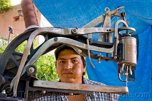 shoemaker chewing coca leaves behind his sewing machine (san salvador de jujuy, argentina), andean carnival, argentina, chewing, coca leaves, crank sewing machine, jujuy capital, man, noroeste argentino, san salvador de jujuy, shoe machine, shoemaker