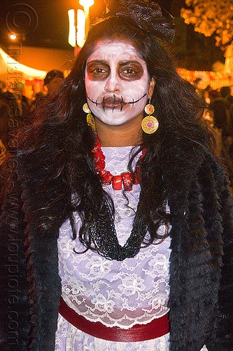 skull makeup and lace dress, day of the dead, dia de los muertos, dramatic, face painting, facepaint, halloween, lace dress, latino woman, night, red necklace, sad, skull makeup, white dress, yellow earrings