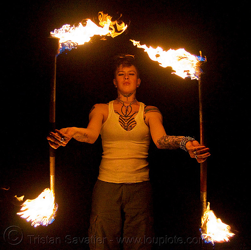 spinning fire staffs (san francisco) - fire dancer - leah, double staff, fire dancer, fire dancing, fire performer, fire spinning, fire staffs, fire staves, leah, night, spinning fire, tattooed, tattoos, woman