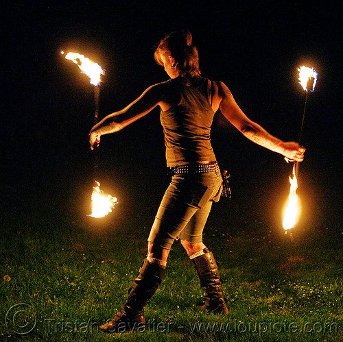 spinning fire staves on the grass - leah, backlight, boots, fire dancer, fire dancing, fire performer, fire spinning, fire staffs, fire staves, grass, lawn, leah, low key, night, woman