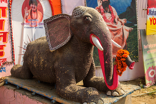 statue of elephant laying down (india), elephant, hindu pilgrimage, hinduism, kumbh mela, laying down, orange flowers, pink trunk, sculpture, statue