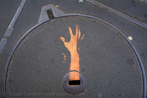 stencil graffiti on manhole cover - hand (paris, france), arm, graffiti, hand, help!, manhole cover, plaque d'egout, plaque d'égout, regard de chaussée, stencil, street art, tampon de regard