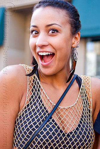 surprise facial expression, feather earrings, fishnet clothing, mesh, woman