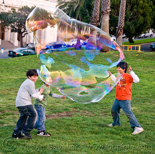 three kids playing with giant soap bubble, big bubble, children, giant bubble, iridescent, kids, lawn, park, playing, soap bubbles