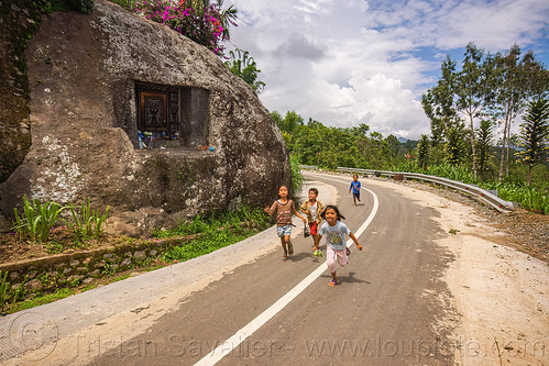 toraja kids running near a rock-tomb, boys, burial site, cemetery, children, grave, graveyard, kids, liang pak, little girls, playing, road, rock tomb, running, tana toraja