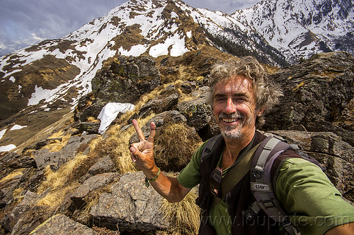 tristan savatier - mountain hiking in the indian himalayas near joshimath (india), hiking, man, mountains, peace sign, rocks, self-portrait, selfie, snow patches, trekking, v sign, victory sign