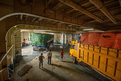 trucks getting parked on the deck of the ro-ro ferryboat ship, boat, deck, dharma ferry, ferryboat, inside, interior, men, ship, surabaya, trucks