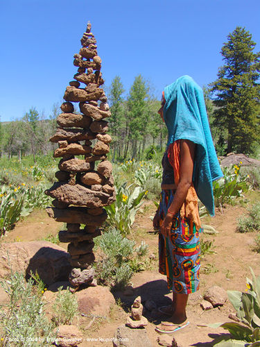 very tall and unstable cairn - rainbow gathering 2004, asha, hippie, rocks, stone cairn, woman