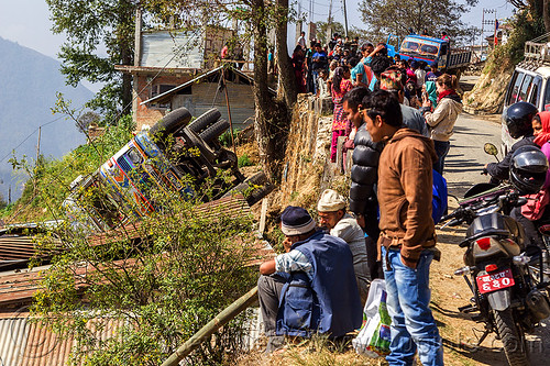 villagers looking at overturned truck in ditch (nepal), crash, ditch, lorry accident, motorcycle, mountain road, overturned, rollover, tata motors, traffic accident, truck accident, up-side-down, wreck