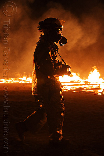 volunteer firefighter in fire-protection suit - burning man 2010, backlight, burning man, dust mask, fire suit, fire-protection suit, firefighter, night of the burn, respirator, safety helmet, smoke mask