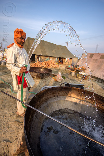 washing a large cooking pot at kumbh mela 2013 (india), ashram, big, cooking pot, hindu pilgrimage, hinduism, huge, kumbh mela, large, man, washing, water droplets, water hose