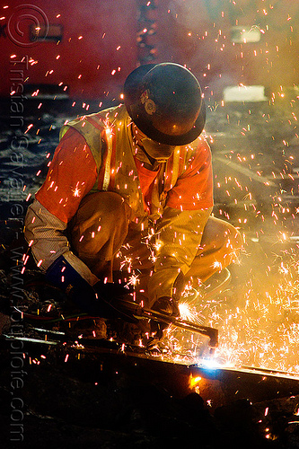 welder uses oxy-acetylene cutting torch to cut track rails, dust mask, fire, high-visibility jacket, high-visibility vest, light rail, man, muni, night, ntk, oxy-acetylene cutting torch, oxy-fuel cutting, railroad construction, railroad tracks, railway tracks, reflective jacket, reflective vest, safety glasses, safety helmet, safety vest, san francisco municipal railway, sparks, track maintenance, track work, welder, worker, working