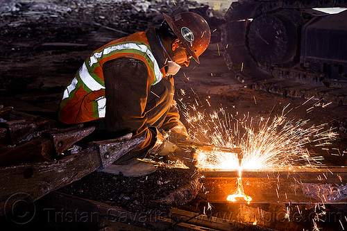 welder using cutting torch to cut a rail, demolition, high-visibility jacket, high-visibility vest, light rail, man, muni, night, ntk, oxy-acetylene cutting torch, oxy-fuel cutting, railroad construction, railroad tracks, railway tracks, reflective jacket, reflective vest, safety helmet, safety vest, san francisco municipal railway, sparks, track maintenance, track work, welder, welding, worker, working