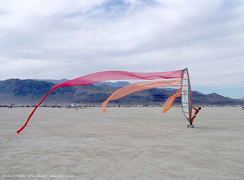 windsurfing on the playa - burning man 2004 - landsailing, dust storm, landsailing, streamer flags, streamers, street sailing, windsurfing