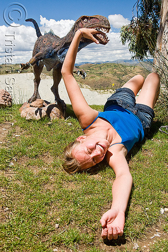 woman attacked by velociraptor, ania, bite, biting, bolivia, dinosaur park, grass, hand, head, lawn, laying down, parque cretacico, parque cretácico, sucre, teeth, velociraptor, woman