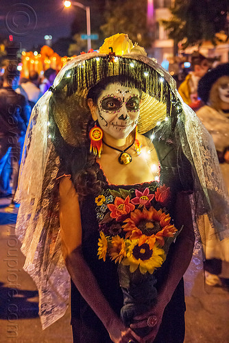 woman holding flower bouquet - dia de los muertos, bouquet, christmas lights, day of the dead, dia de los muertos, face painting, facepaint, flowers, halloween, hat, lace veil, night, sugar skull makeup, sunflowers, tassel fringe, woman