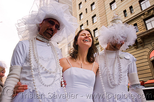 woman laughing between two men dressed as brides - brides of march (san francisco), bride, brides of march, men, necklaces, wedding dress, white, woman
