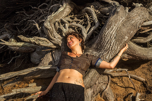 woman laying on twisted juniper tree roots, belly tattoo, juniper, laying down, roots, tree, woman, yassmine