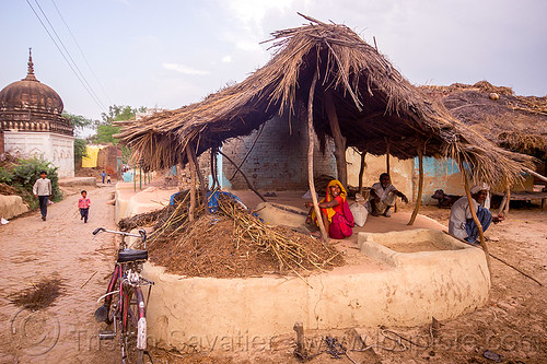 woman sitting in outdoor kitchen in indian village, adobe floor, bicycle, earthen floor, house, khoaja phool, kitchen, men, monument, shrine, sitting, temple, village, woman, खोअजा फूल