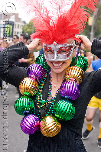 woman with carnival mask and large carnival beads, bay to breakers, carnival mask, costume, feather mask, footrace, mardi gras beads, mardi gras mask, masquerade mask, necklaces, red feathers, street party, woman