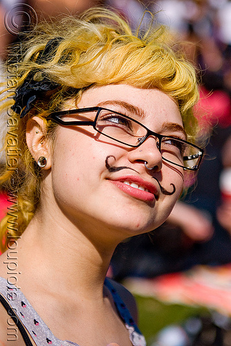 woman with mustache makeup, ear piercing, eyeglasses, eyewear, gay pride festival, glasses, mustache makeup, nose piercing, septum piercing, spectacles, woman, yellow hair