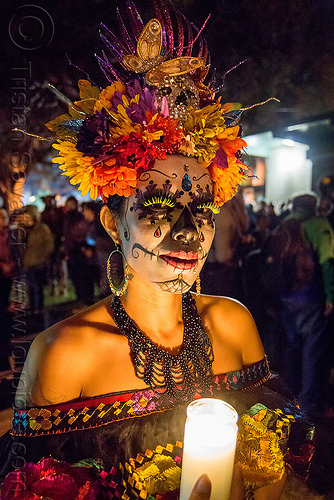 woman with sugar skull makeup and flower headdress - candle light - dia de los muertos, bindis, butterfly headdress, candle light, day of the dead, dia de los muertos, earrings, face painting, facepaint, fake eyelashes, flower headdress, glass candle, green eyelashes, halloween, necklace, night, sugar skull makeup, woman